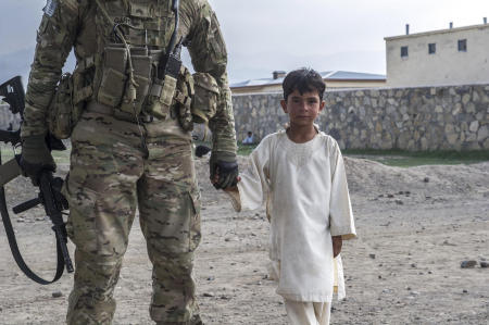 Tani District, Khost Province, Afghanistan- A US Army sergeant assigned to the 1st Infantry Division holds the hand of Ramn Akbal Khan, a student at the local elementary school. With the help of an interpreter and a member of the Afghan National Amy, the student and the sergeant shared culture-based education, with the student teaching the sergeant about local customs, and the sergeant teaching the student about security in the region. 
Published by National Geographic.